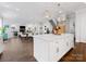 Open-concept kitchen with large island, modern light fixtures, and hardwood floors extending into the dining and living areas at 1900 Nassau Blvd, Charlotte, NC 28205
