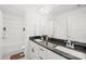 Well-lit bathroom features double sinks with dark countertops and white cabinets, next to a bathtub at 2007 Lydney Cir, Waxhaw, NC 28173