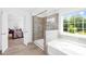 Bathroom with glass shower, soaking tub, and view to the backyard at 2007 Lydney Cir, Waxhaw, NC 28173