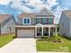 Beautiful two-story home boasting a manicured lawn, brick facade, and attached two-car garage at 2007 Lydney Cir, Waxhaw, NC 28173