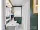 Stylish bathroom with dark green walls, a white sink, and a shower with a white curtain at 2110 Winter St, Charlotte, NC 28205