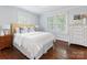 Well-lit bedroom with gleaming hardwood floors, a comfy bed, and classic white dresser at 2110 Winter St, Charlotte, NC 28205
