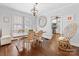 Inviting dining room featuring a rustic wood table with seating, chandelier, and light from the windows at 2110 Winter St, Charlotte, NC 28205