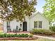 Charming white brick home featuring a cozy front porch with rocking chairs and manicured landscaping at 2110 Winter St, Charlotte, NC 28205