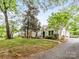 Charming front exterior with well-manicured lawn and lush trees, showcasing curb appeal at 2110 Winter St, Charlotte, NC 28205