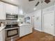 Open kitchen with stainless steel appliances, quartz countertops, and hardwood floors at 2110 Winter St, Charlotte, NC 28205