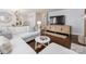 Bright living room with hardwood floors, white sectional sofa, TV and decorative cabinet at 2110 Winter St, Charlotte, NC 28205