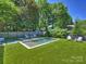 Serene backyard with a modern pool, lounge area, and manicured artificial turf at 2121 Club Rd, Charlotte, NC 28205