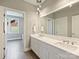 Bright bathroom featuring double sink vanity with drawers, an oversized mirror and pendant lights at 2121 Club Rd, Charlotte, NC 28205