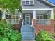 Inviting front porch featuring brick accents, white columns, and steps leading to a charming entrance at 2121 Club Rd, Charlotte, NC 28205