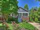 Charming home with a welcoming front porch, beautiful landscaping, and colorful roses in the front yard at 2121 Club Rd, Charlotte, NC 28205