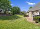 A spacious backyard featuring a manicured lawn, mature trees, and a patio with a grill at 2467 Chatham Dr, Fort Mill, SC 29707