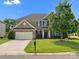 Charming brick home with a lush green lawn, mature trees, and a well-maintained garden at 2467 Chatham Dr, Fort Mill, SC 29707