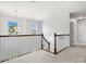 Upstairs hallway with wooden railings, carpeted floors, bright windows, and decorative lighting at 2467 Chatham Dr, Fort Mill, SC 29707