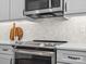 Close up of kitchen featuring stainless steel oven and cooktop, with white cabinets and marble backsplash at 2467 Chatham Dr, Fort Mill, SC 29707