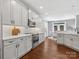Well-lit kitchen featuring white cabinets, stainless steel appliances, and hardwood floors, seamlessly connecting to dining area at 2467 Chatham Dr, Fort Mill, SC 29707