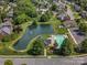Aerial view of a community featuring a pool, lake, and lush green landscaping at 2467 Chatham Dr, Indian Land, SC 29707