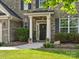 Elegant front entrance with black door, white pillars, and landscaped garden at 2467 Chatham Dr, Indian Land, SC 29707