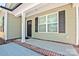 Charming front porch featuring brick detail, a black front door, and green siding at 2502-2504 Glendale Ave, Kannapolis, NC 28081