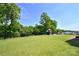 Large backyard with a playset, lush green grass, and trees at 262 Country Lake Dr, Mooresville, NC 28115