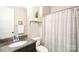 Well-lit bathroom features a granite countertop vanity and a shower with patterned curtain at 262 Country Lake Dr, Mooresville, NC 28115