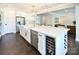 Modern white kitchen features a large island with wine cooler and stainless steel appliances at 262 Country Lake Dr, Mooresville, NC 28115