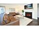 Cozy living room with fireplace, TV, hardwood floors, and comfortable brown leather furniture at 262 Country Lake Dr, Mooresville, NC 28115