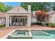 Backyard oasis featuring a pool, spa, patio, outdoor kitchen, and lush landscaping for ultimate relaxation at 2900 Wickersham Rd, Charlotte, NC 28211