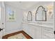 Bathroom with double vanity, marble countertop, hardwood floors and decorative mirrors with sconces at 2900 Wickersham Rd, Charlotte, NC 28211