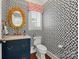 Stylish powder room with a modern sink, gold fixtures, designer wallpaper, and natural light from the window at 2900 Wickersham Rd, Charlotte, NC 28211