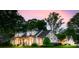 Elegant exterior view of a white brick home at dusk, showcasing the architecture and manicured landscaping at 2900 Wickersham Rd, Charlotte, NC 28211
