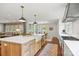 Open-concept kitchen featuring a large island, farmhouse sink, stainless steel appliances, and hardwood floors at 2900 Wickersham Rd, Charlotte, NC 28211