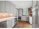 Stylish kitchen with grey cabinets, brick backsplash, modern appliances, and hardwood flooring at 2900 Wickersham Rd, Charlotte, NC 28211