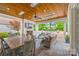 Inviting outdoor patio with stone flooring, fireplace, dining table, and comfortable seating overlooking pool at 2900 Wickersham Rd, Charlotte, NC 28211