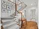 Charming staircase with decorative elements and wood railing leading to a hallway with hardwood floors at 2900 Wickersham Rd, Charlotte, NC 28211