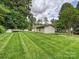 Expansive backyard featuring lush lawn and a detached garage, all enclosed by a classic white fence at 3128 Country Club Dr, Charlotte, NC 28205