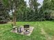 Charming backyard patio area featuring comfortable seating amidst a lush green lawn and shade trees at 3128 Country Club Dr, Charlotte, NC 28205
