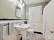 Traditional bathroom with pedestal sink, black and white tiled floors, and plantation shutters at 3128 Country Club Dr, Charlotte, NC 28205