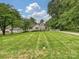 Charming home surrounded by mature trees and a lush lawn, offering a serene and picturesque setting at 3128 Country Club Dr, Charlotte, NC 28205