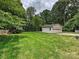 Detached garage with a well-manicured lawn and surrounding trees at 3128 Country Club Dr, Charlotte, NC 28205