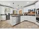Well-appointed kitchen features stainless appliances, stone countertops, wine storage, and bright white cabinetry at 3128 Country Club Dr, Charlotte, NC 28205