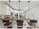 Spacious kitchen features a bar, pendant lights, stainless appliances, and ample white cabinetry at 3128 Country Club Dr, Charlotte, NC 28205
