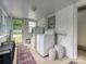 Well-lit laundry room with white brick walls, modern washer and dryer, and functional storage at 3128 Country Club Dr, Charlotte, NC 28205
