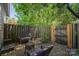 Backyard with patio featuring outdoor seating under lush green tree and fence views at 3131 Heathstead Pl, Charlotte, NC 28210