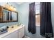 Bright bathroom with a vanity sink, large mirror, and a window at 3131 Heathstead Pl, Charlotte, NC 28210