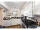 Bright kitchen with white cabinets, black countertops, stainless steel appliances and a large window at 3131 Heathstead Pl, Charlotte, NC 28210