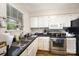 Bright kitchen with white cabinets, black countertops, stainless steel appliances and a large window at 3131 Heathstead Pl, Charlotte, NC 28210