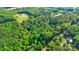 Aerial view of property showcasing lush forest, neighboring farmland and a distant white house at 332 York Spann Rd, Hamptonville, NC 27020