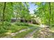 View of a brick house with a carport and landscaped front yard, showcasing its curb appeal at 332 York Spann Rd, Hamptonville, NC 27020