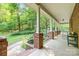 Covered porch with brick and wood columns, overlooking a tranquil garden with a stone pond at 332 York Spann Rd, Hamptonville, NC 27020